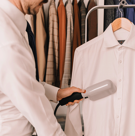 A man steaming a white shirt with the Laurastar Izzi steamer