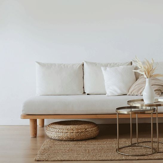 Living room with a white sofa, beige rug and coffee tables to illustrate how to remove stains from home textiles: Sofas, armchairs, rugs, tablecloths and more